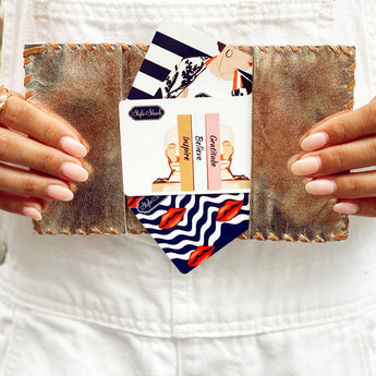 A girl in white overalls holding a wallet with gift cards spilling out