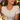 Smiling woman in a white top wearing the gold black bead fringe necklace at an outdoor dinner