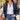 Gold paper clip chain toggle necklace with a pearl drop worn with a white shirt, navy blazer, jeans and a tan leather tote on a city sidewalk