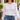 Woman walking outdoors in a white long-sleeve tee and jeans wearing the gold Triangle Moonstone Y Necklace