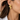 Woman wearing the Aviva gold leaf earring with a white shirt