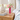 Faceted Acrylic Bud Vase, Pink, on a rattan nightstand