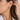 Close-up of a woman wearing the Eva chunky gold hoop earring with a white collared shirt