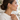 Side profile of woman in cream sweater wearing gold cable hoop