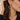 Close-up of a gold flower crystal drop earring worn