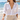 LIZOU green enamel fish charm necklace worn with a white linen shirt at the beach
