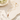 LIZOU pink enamel mini fish necklace laid flat on a cream stone surface