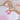Hand dropping a pink Musee bath balm into a bathtub