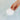 Hand placing a white Musee bath tablet into water