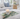 Palm leaf acrylic vanity tray with a candle on an ottoman